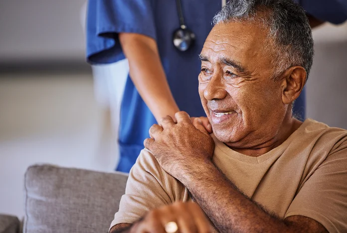 Caregiver holding an elderly person’s hand during a support session